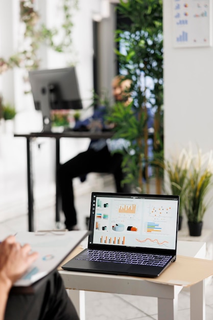 Free Photo employee reviewing sales data on laptop screen and budgeting strategy in business office. worker analyzing metrics statistics charts on portable computer in coworking space