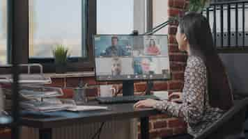 Free photo employee talking to workmates on online video call, meeting to discuss business project. woman using remote teleconference on computer with colleagues. video conference on webcam