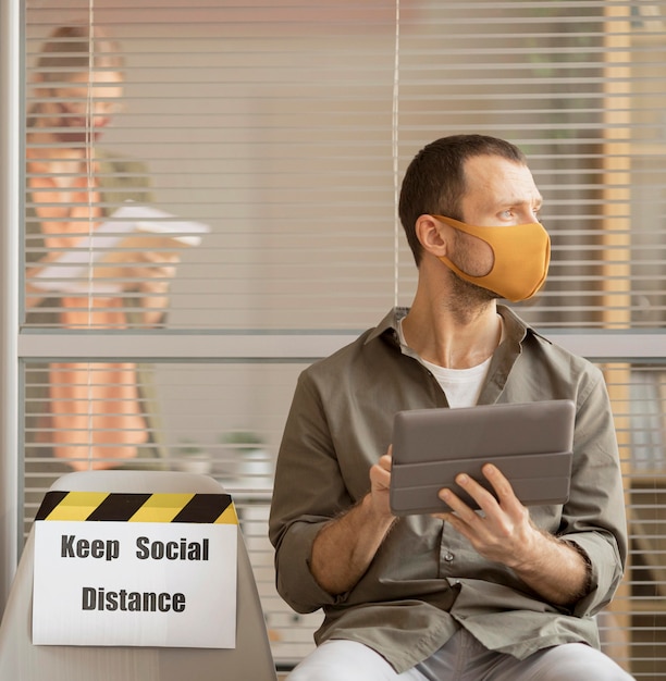 Free Photo employee wearing face mask taking a break