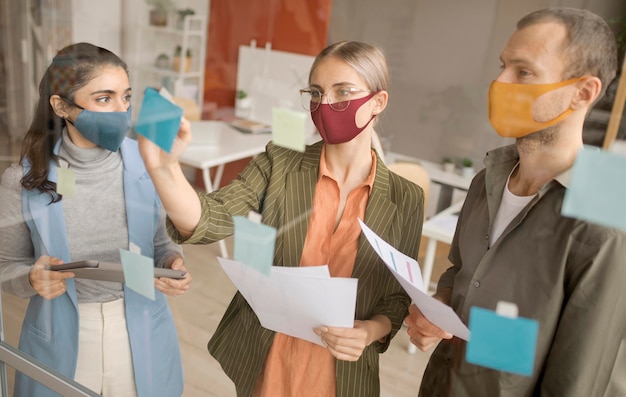 Free photo employees wearing face masks at the office