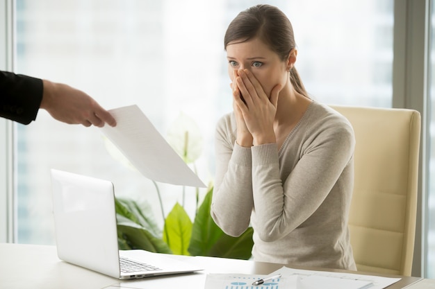 Employer giving dismissal notice to young woman