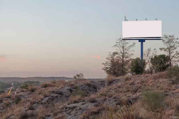 Free photo an empty advertising billboard on mountain against sky