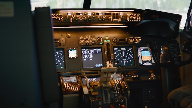 Empty airplane cockpit with dashboard and control panel command, electronic aircraft radar. No people in plane cabin with navigation, lever, switch and compass to takeoff. Handheld shot.