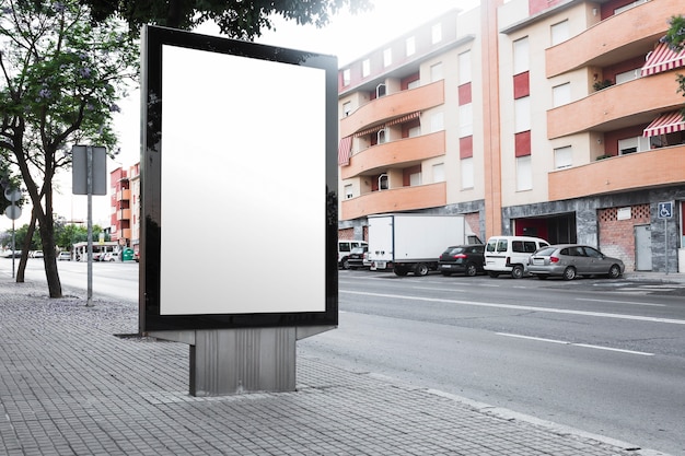 An empty billboard on the sidewalk near the roadside