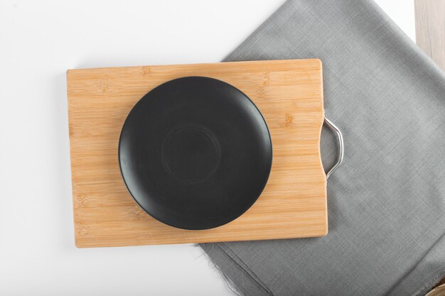 An empty black ceramic saucer