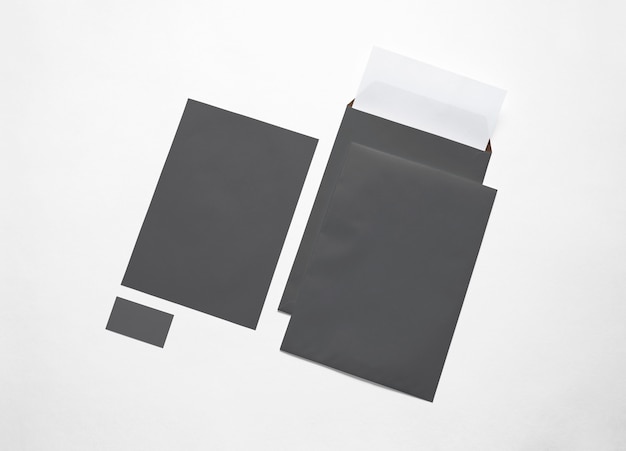 Empty black paper envelopes, letterheads and card isolated on white. 3d illustration.