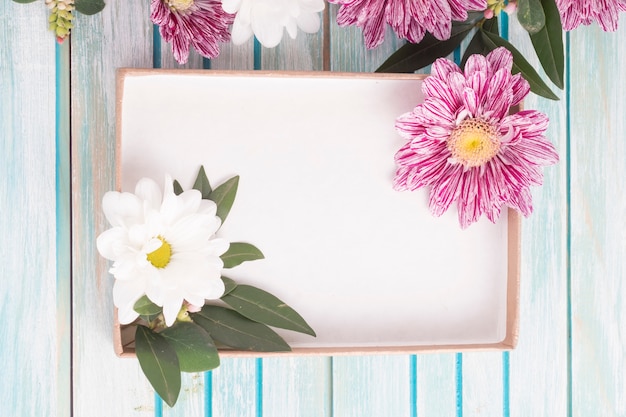 Free photo an empty box with daisy and chrysanthemum flowers