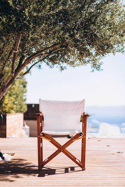 Free photo empty chair under the palm at the beach