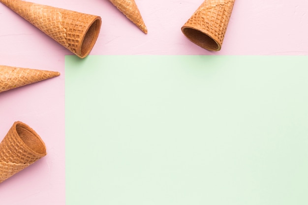 Empty crispy ice cream cones on multicolored surface