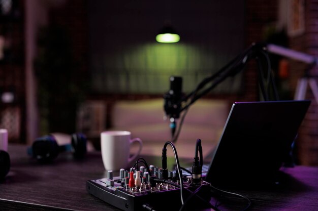 Empty desk with podcast equipment to record live talking show at home. No people in living room used for online vlogging and broadcasting conversation with microphone, sound production.