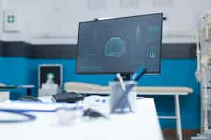 Free photo empty doctor office with computer having anatomical body skeleton radiography on computer screen during clinical consultation. hospital room equipped with professional medical tools. medicine concept