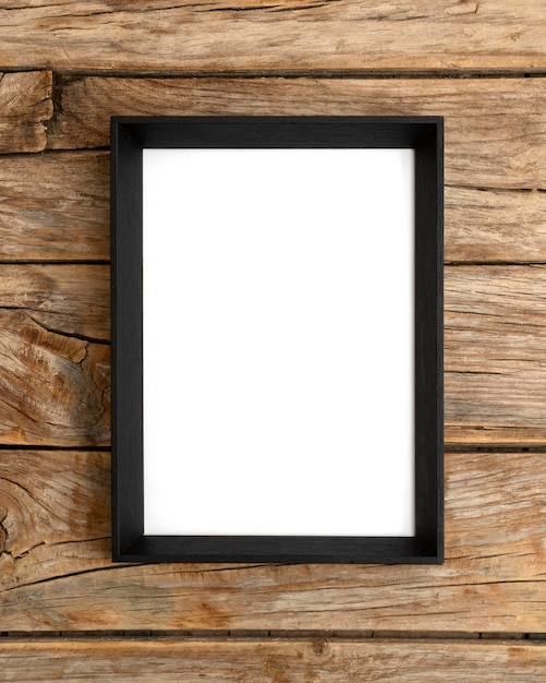 Empty frame on wooden wall