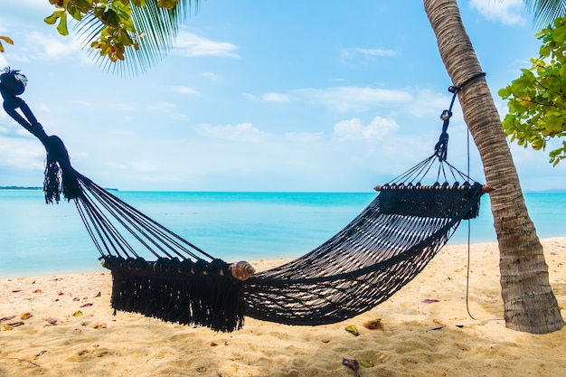 Free Photo empty hammock swing around beach sea ocean with white cloud blue sky for travel vacation