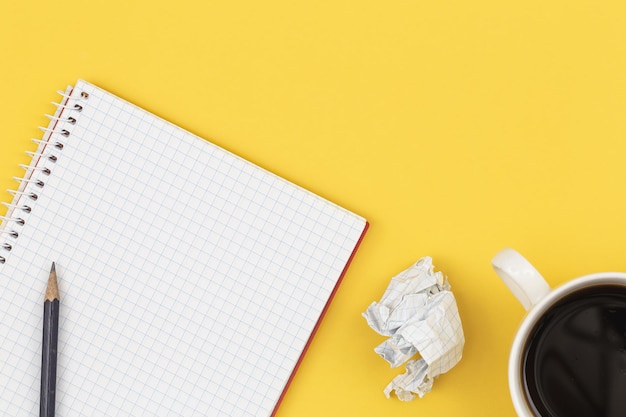 Free Photo empty notebook with cup of coffee and crumpled paper balls flat lay