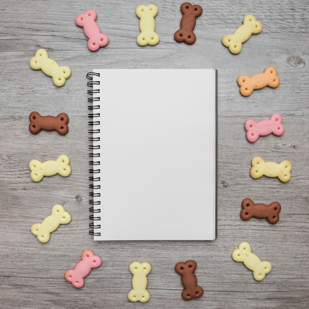 Free photo empty notebook with dog snacks around