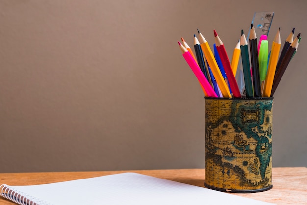 Free photo empty notepad near cup with pencils