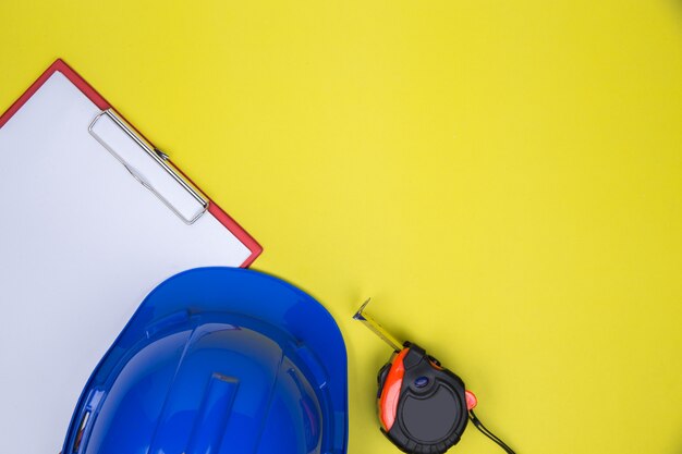 Free Photo empty paper, measuring tape and work helmet