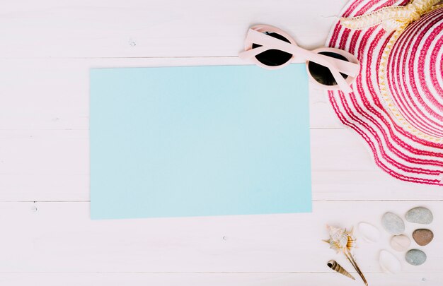 Empty paper with summer accessories on light background