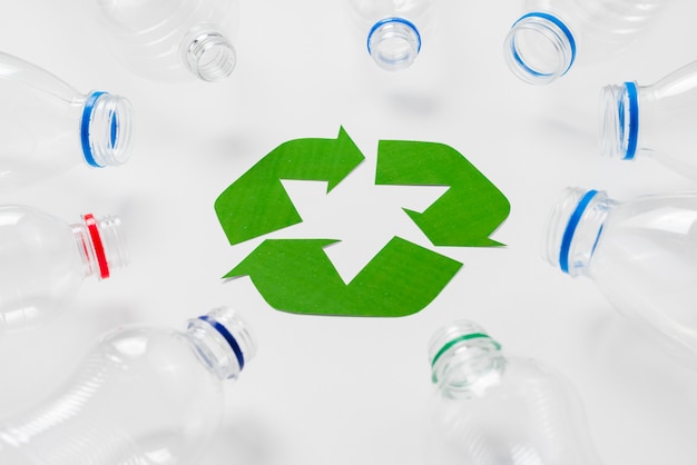 Free photo empty plastic bottles around recycling logo