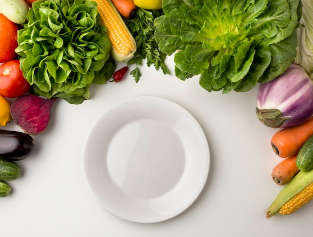 Free photo empty plate with vegetable arrangement