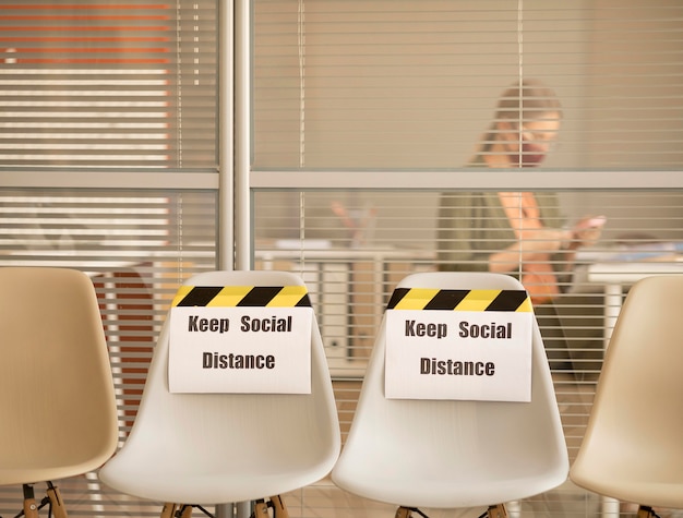 Free photo empty seats with social distance sign at work