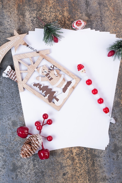 Empty sheets of paper with Christmas decoration on marble space. 