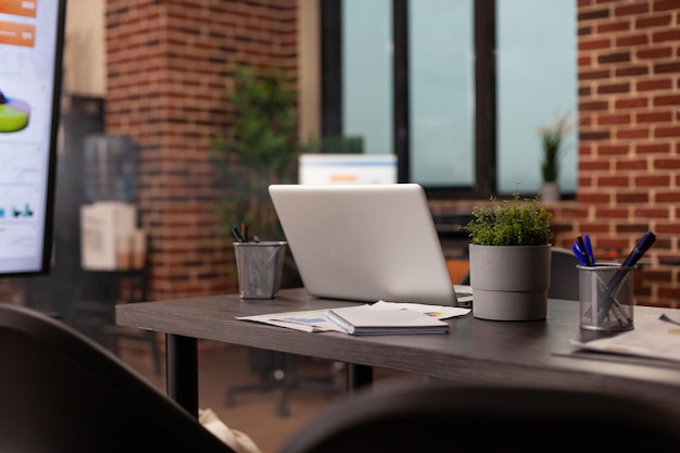 Empty start-up company office with nobody in it waiting for people to start working at financial documents during business meeting. Workplace with modern furniture, management graphs on computer