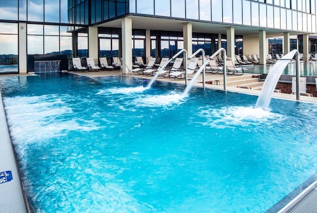 Empty swimming pool with hydrotherapy showers at health spa Copy space