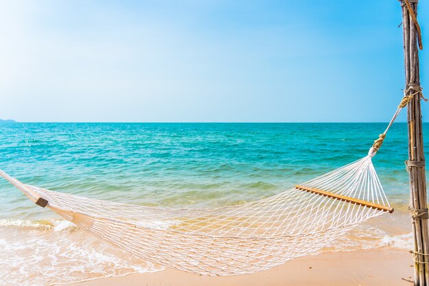 Empty white hammock around sea beach ocean for leisure travel vacation concept