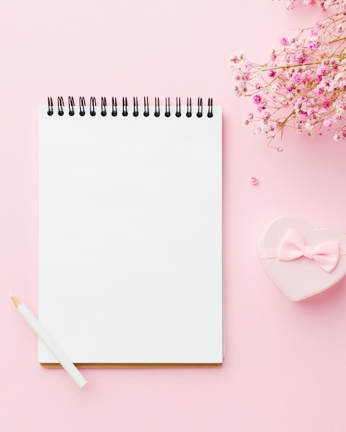 Empty white notepad and flowers top view