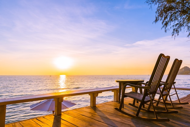 Free photo empty wood chair and table at outdoor patio with beautiful tropical beach and sea