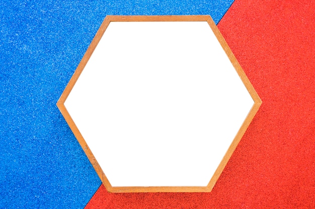 Free photo an empty wooden hexagon frame on red and blue background