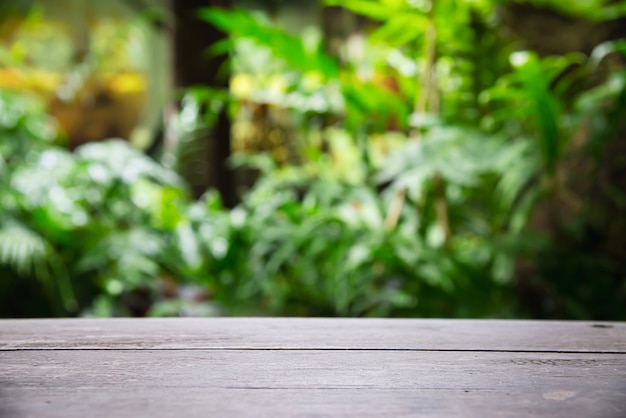 Empty wooden plank floor space with green garden leaves , product display space with fresh green nature  