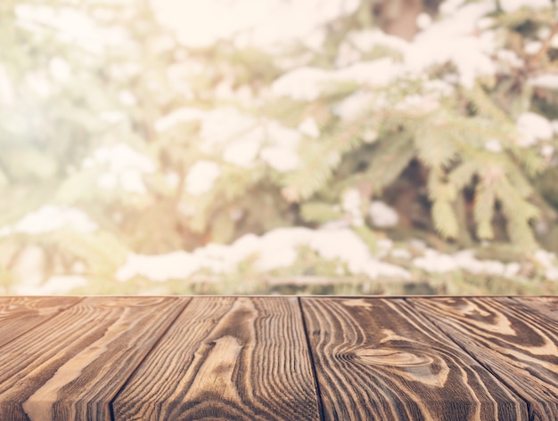 An empty wooden table with defocused trees