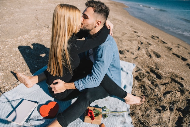 Free photo enamored couple kissing on sandy beach