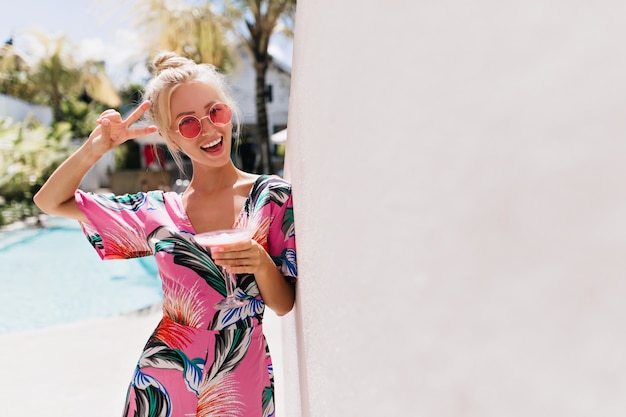 Enchanting girl in pink dress has a good time at summer resort.