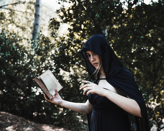 Free Photo enchantress with spellbook in sunny woods