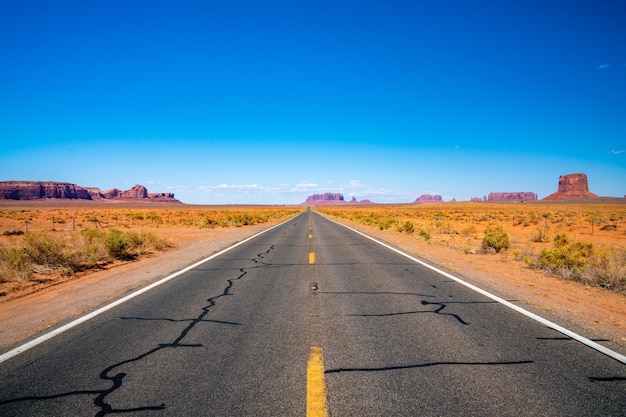 Endless road through the Monument Valley National park with amazing rock formations