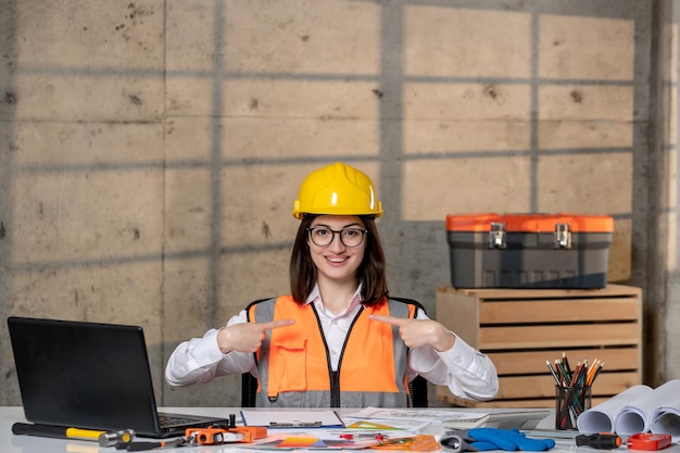 Engineer cute young smart brunette girl civil worker in helmet and vest focused