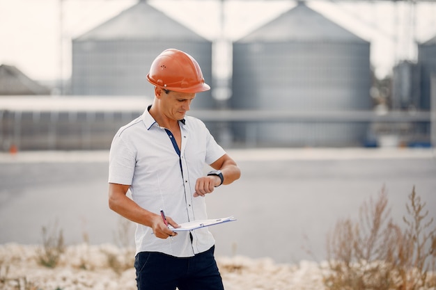 Engineer in a halmet standing by the factory