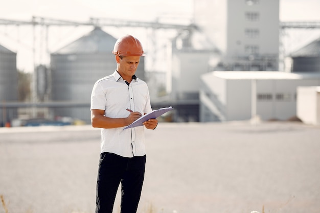 Free photo engineer in a helmet standing by the factory