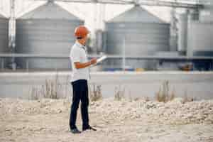 Free photo engineer in a helmet standing by the factory