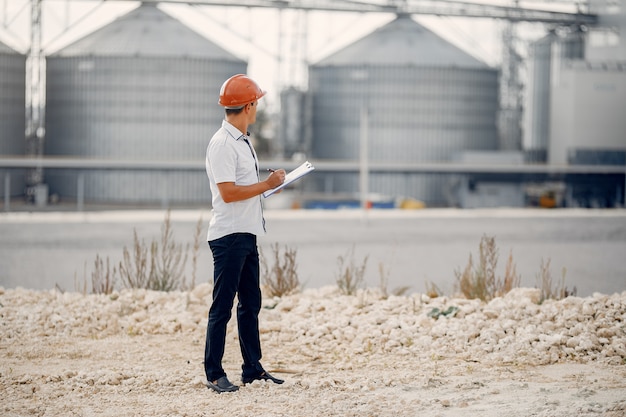 Free Photo engineer in a helmet standing by the factory