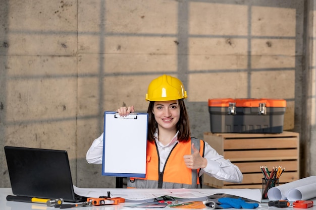 Engineer in helmet and vest civil worker smart young cute brunette girl happy