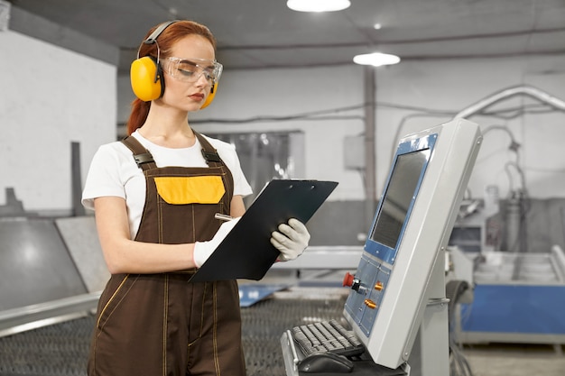 Free photo engineer holding folder, operating computerized machine.