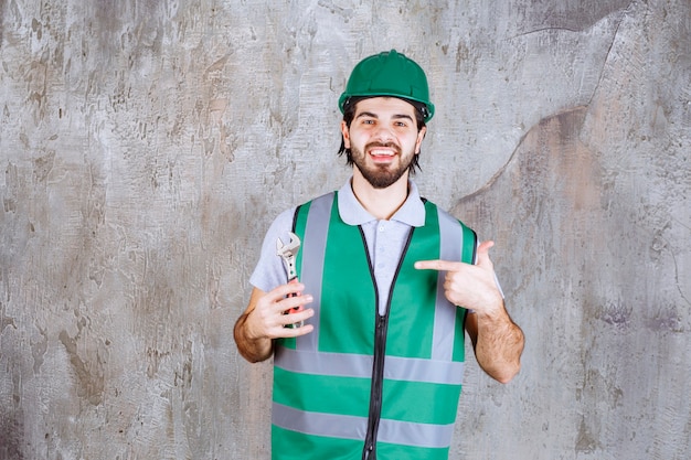 Free Photo engineer in yellow gear and helmet holding a metallic wrench.