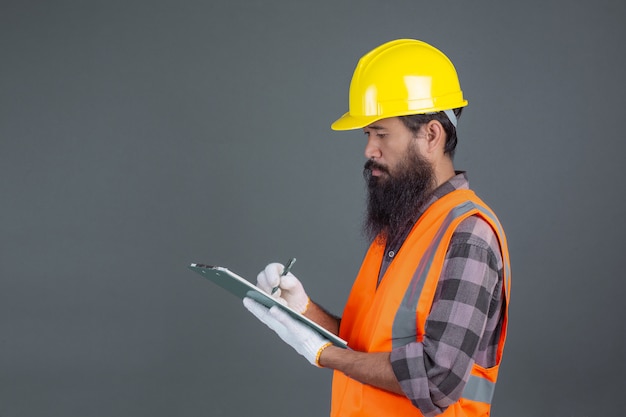 An engineering man wearing a yellow helmet with a design on a gray .