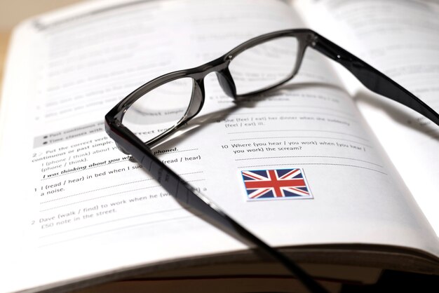 English book with glasses on table