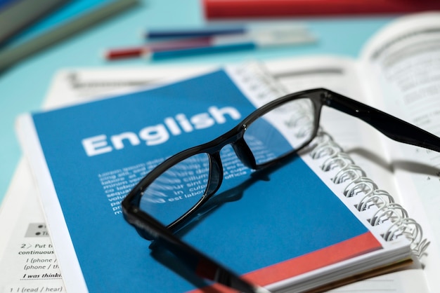 Free photo english book with glasses on table