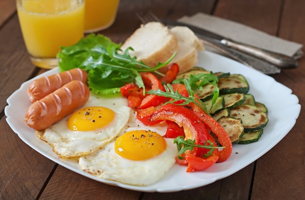 English breakfast - fried eggs, sausages, zucchini and sweet peppers